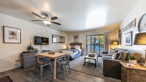 A spacious living area with a dining table, sofa, and a large bed. - 245 Bldg C 1 Bedroom Condo (Truckee)