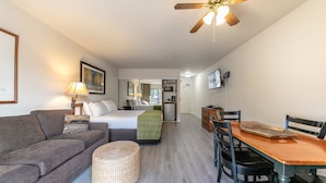 A modern, well-lit room with a bed, a sofa, a dining table, and a ceiling fan. - 234 Bldg C 1 Bedroom Condo (Truckee)
