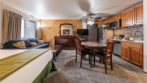 A compact hotel room with a sofa, a dining table, and a kitchenette. - 113 Bldg B 1 Bedroom Studio (Truckee)