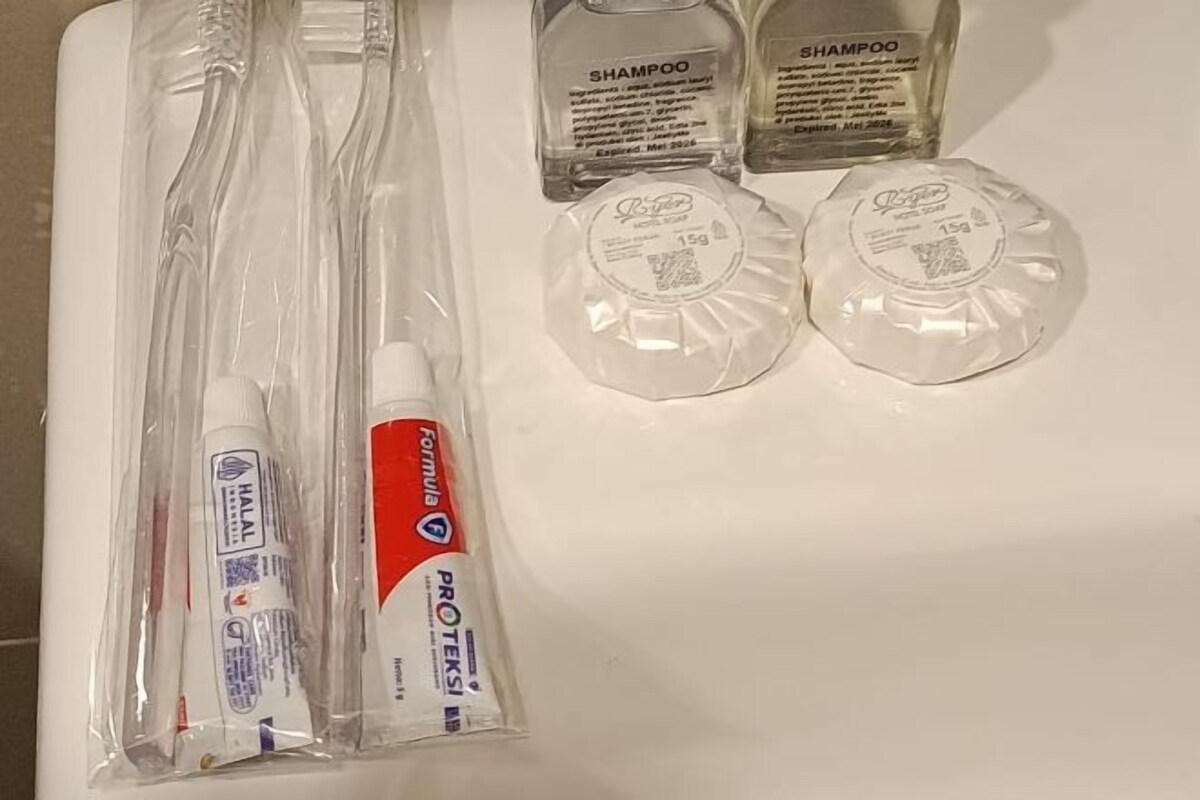 Un meuble-lavabo de salle de bain contenant des articles de toilette, notamment une brosse à dents, du dentifrice, du shampoing et un rasoir.