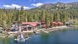 A lakeside lodge with multiple buildings, docked boats, and a forested mountain backdrop. - 111 Bldg B Condo (Truckee)