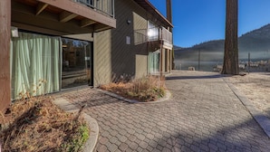 A modern building with a balcony, large windows, and a paved walkway. - 135 Bldg C 1 Bedroom Condo (Truckee)