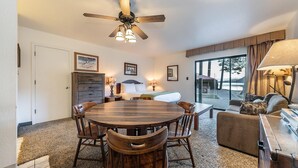 A cozy room with a wooden dining table, chairs, a sofa, and a ceiling fan. - 144 Bldg C 1 Bedroom Condo (Truckee)