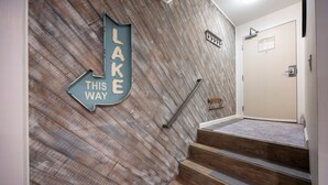 A staircase with wooden steps and a wall with a directional sign. - 124 Bldg B Studio (Truckee)