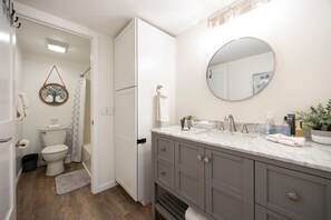 Een moderne badkamer met toilet, wastafel en douche.