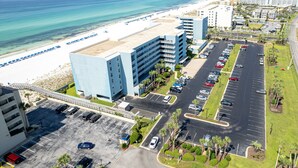 A hotel with a parking lot, beach access, and ocean views.