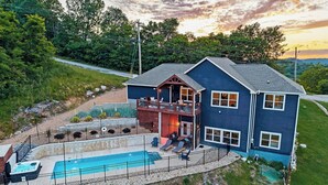 Une maison à deux étages dotée d’une piscine, d’une terrasse et offrant une vue sur le paysage environnant.