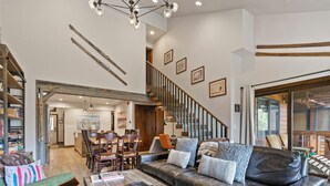A spacious living area with a leather sofa, wooden coffee table, and a staircase leading to an upper level.