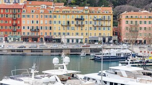 A marina with boats docked, a waterfront promenade, and colorful buildings with shops and restaurants. - Sunlight Properties Archibald - Nice, 2 Beds, holiday rental, balcony & parking (Nice)