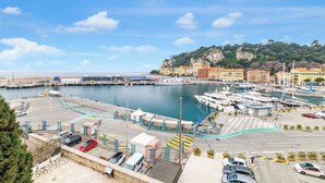 A marina with boats docked, a parking area, and buildings in the background. - Sunlight Properties Archibald - Nice, 2 Beds, holiday rental, balcony & parking (Nice)