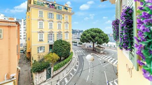A yellow building with a balcony, a tree in front, and a street with cars. - Sunlight Properties Archibald - Nice, 2 Beds, holiday rental, balcony & parking (Nice)