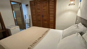 Ein Schlafzimmer mit einem Bett, Holzschränken, einem Nachttisch und einer Wandlampe.