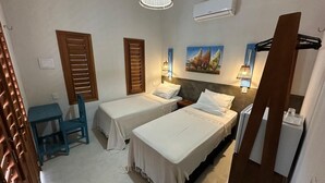 Ein Hotelzimmer mit zwei Betten, einem Schreibtisch und einem Stuhl.