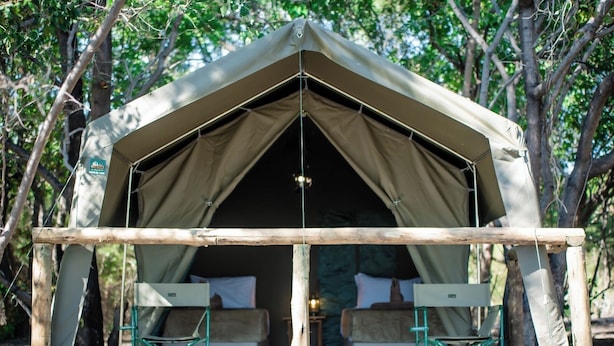 Una carpa con distribución sencilla, que incluye dos camas y una mesa.