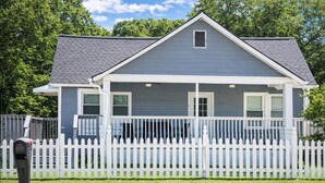 A two-story house with a white picket fence, a front porch, and a mailbox. - World Cup House ATL (Atlanta)