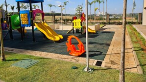 A playground with slides and climbing structures, surrounded by palm trees and a clear sky. - Hospede-se no Solar das Águas (Olímpia)