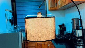 A compact kitchen with wooden cabinets, a gas stove, and a hanging light fixture.