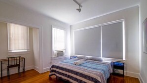 A bedroom with a large bed, a desk, and two windows with blinds. - Miami style gem/central location (Miami)