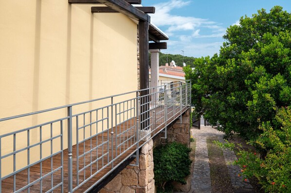 A stone pathway leading to a building with a metal railing.