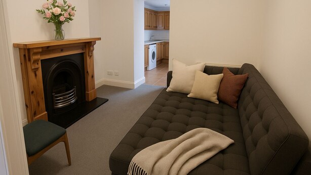 A living room with a dark brown sofa, a wooden fireplace, a small table, and a vase of flowers. - City Centre Location - Sleeps 6 (Galway)
