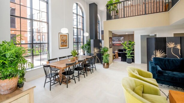 A spacious, modern interior with a dining area, seating, and a balcony. - Zinc Works (Bristol)