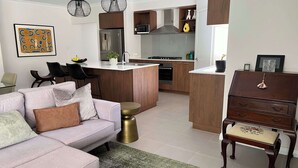 A modern living room with a sofa, a coffee table, and a dining area with chairs. - Mid-century Elegance in a leafy garden (Padbury)