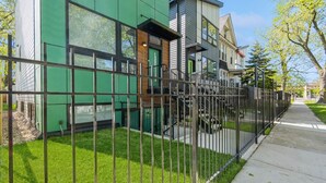 A modern residential building with a green facade, a visible staircase, and a metal fence. - NEW Eco Stay by UChicago, Lakefront & Hyde Park! (Chicago)