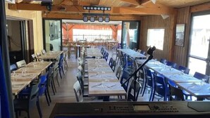 Une longue table à manger avec des chaises, un clavier et un luminaire suspendu au plafond.
