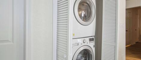 A laundry room with two stacked front-loading washing machines.