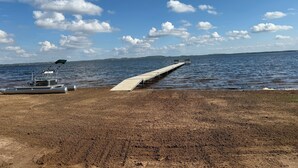 Une jetée s’avançant dans un lac paisible, sous un ciel dégagé.