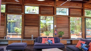 A modern living room with large windows, wooden ceiling, and a sofa set. - Villa Nou Cinq, jungle view, swimming pool and beach 5 min away (Le Gosier)