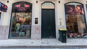 A storefront with a large arched window displaying mannequins and a sign reading "Flamingos Vintage Kitto."
