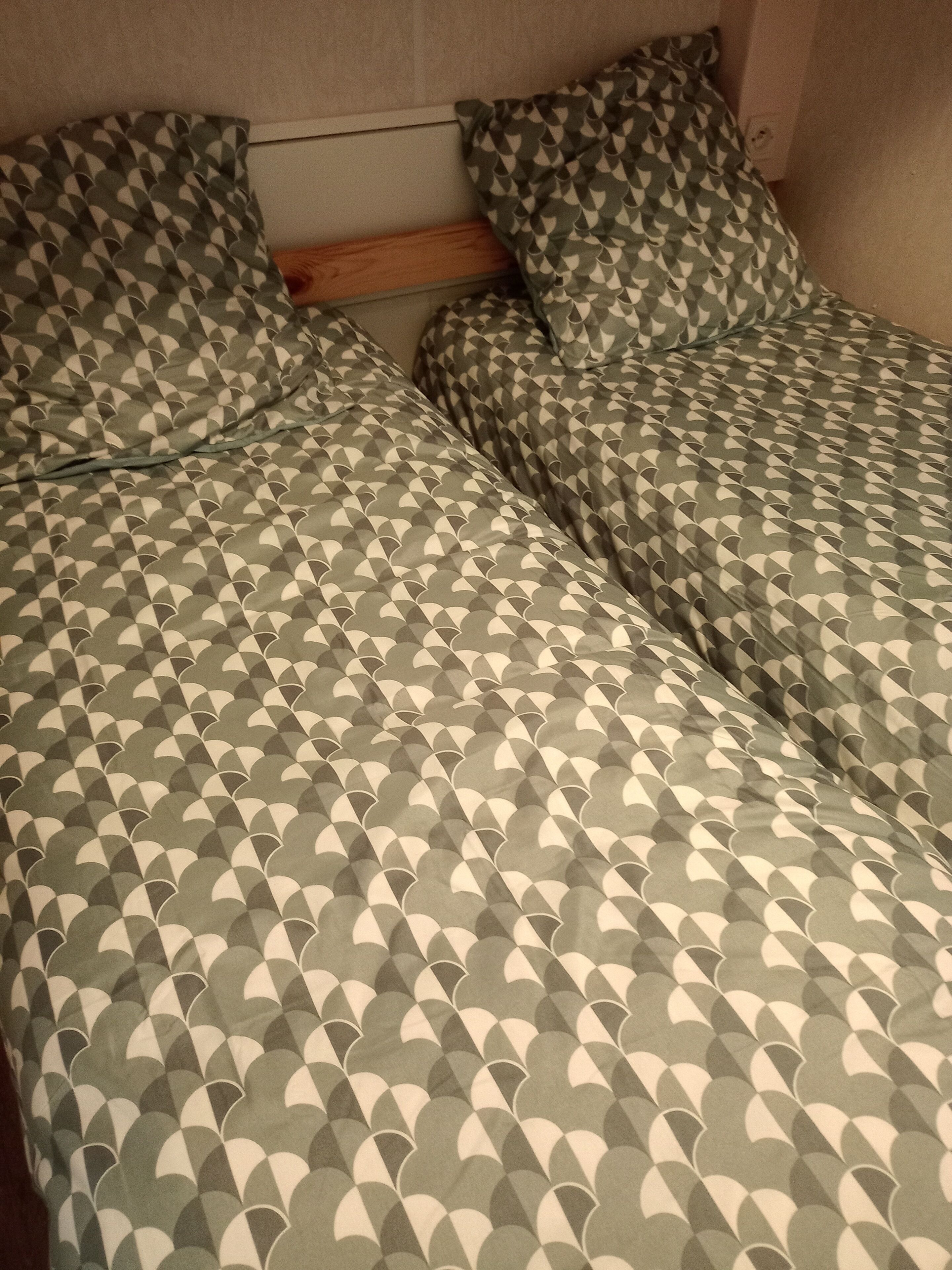 Una cama con colcha y almohadas a cuadros.