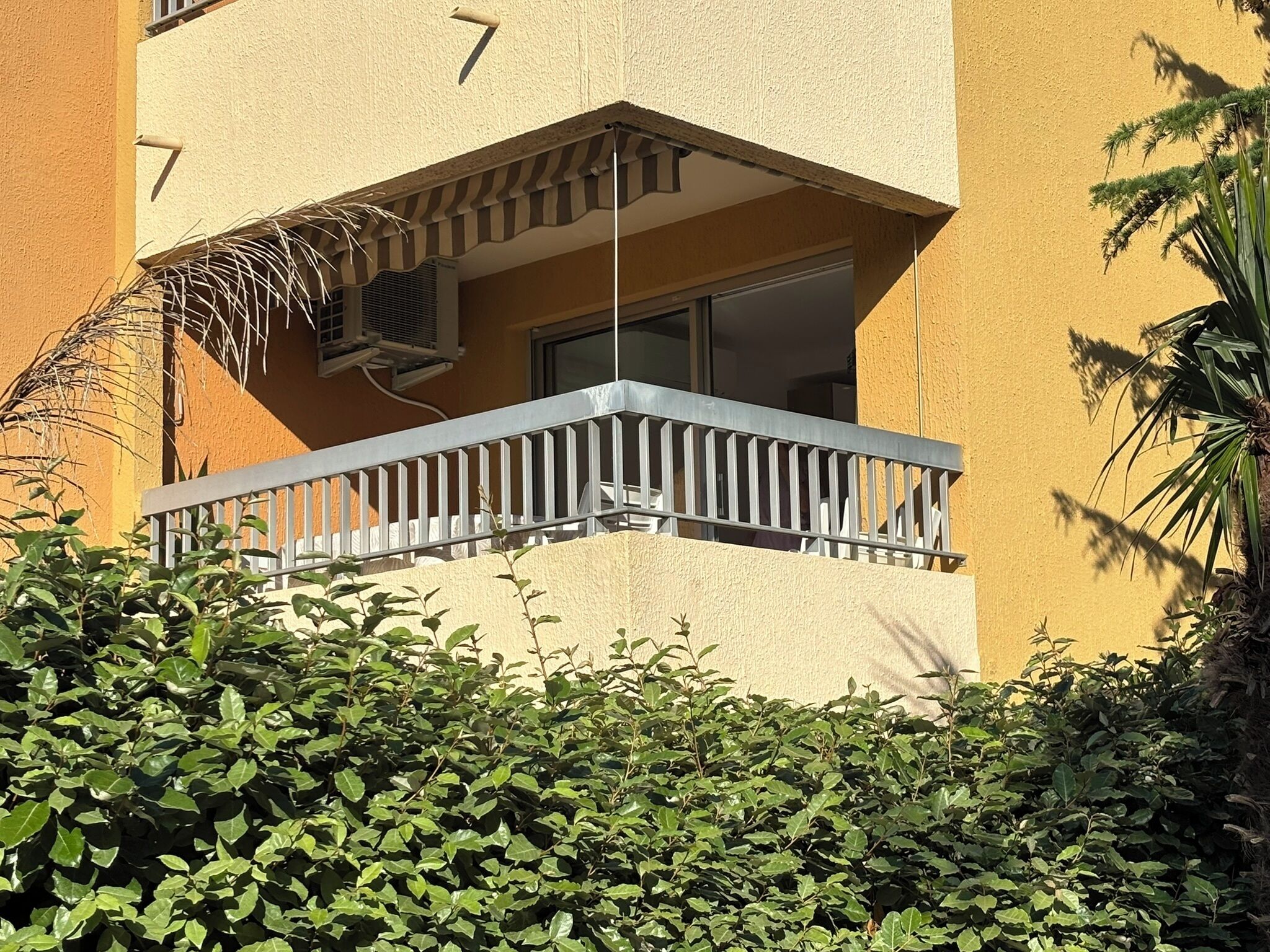 Un edificio con un balcone e condizionatori d'aria, con il numero '7' sulla parete.