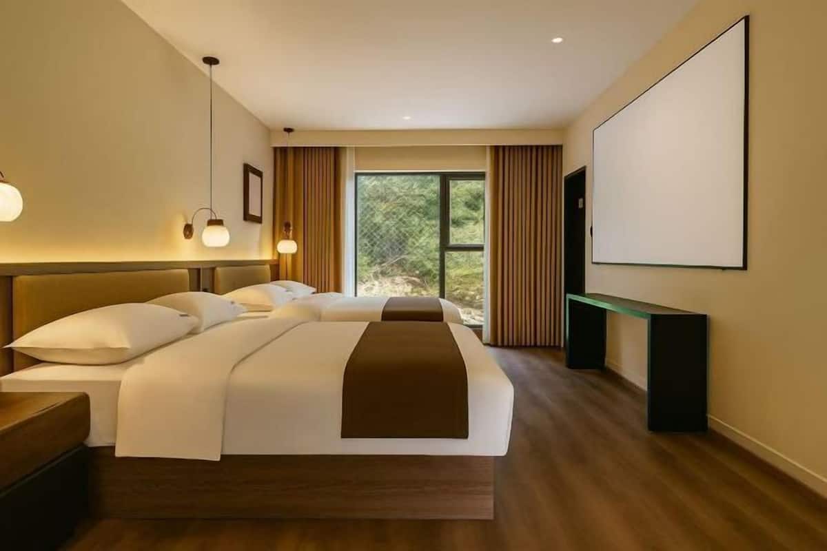 A modern hotel room with a large bed, a desk, and a TV.