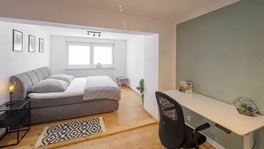 Ein modernes Schlafzimmer mit Bett, Nachttisch und Schreibtisch.