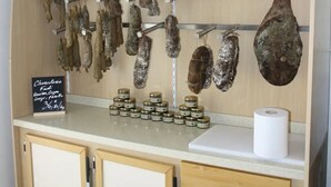 Eine Wurstplatte mit luftgetrockneten Fleischsorten und Gläsern mit Konfitüren.