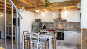 A modern kitchen with white cabinets, a tiled backsplash, and a dining area with a table and chairs. - 900 mt from the historic center of Tortolì and 5 km from all the most beautiful beaches. (Tortolì)