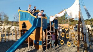 A playground with a slide, climbing structures, and a tent-like structure with ropes. - ZEcamping 3 étoiles piscine chauffée dog friendly locatif TV LV BBQ (Martigues)