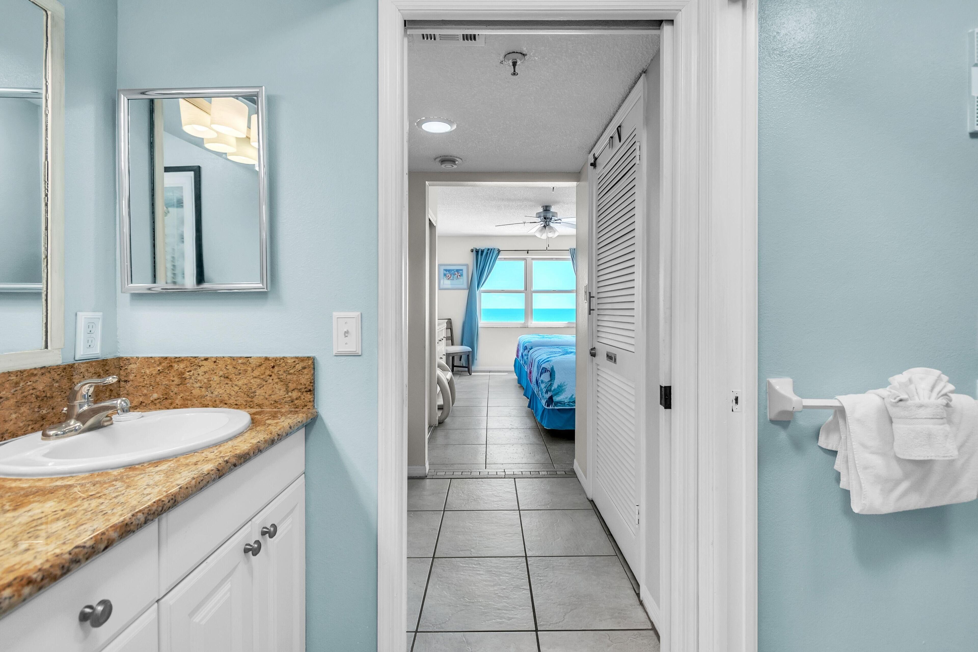 A bathroom with a sink, mirror, and towel rack.