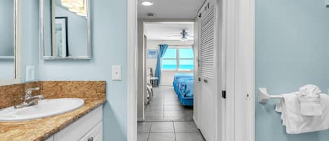 A bathroom with a sink, mirror, and towel rack.