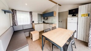 A compact kitchen with a dining area, built-in cabinets, and a microwave.