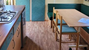 Eine kleine Küche mit Herd, Schränken und einem grünen Sofa.