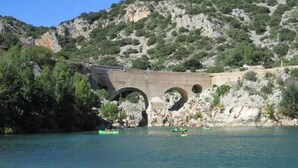 Eine Brücke über Wasser mit einer Berglandschaft im Hintergrund.