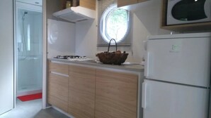 A modern kitchen with a built-in microwave, a gas stove, and a refrigerator.