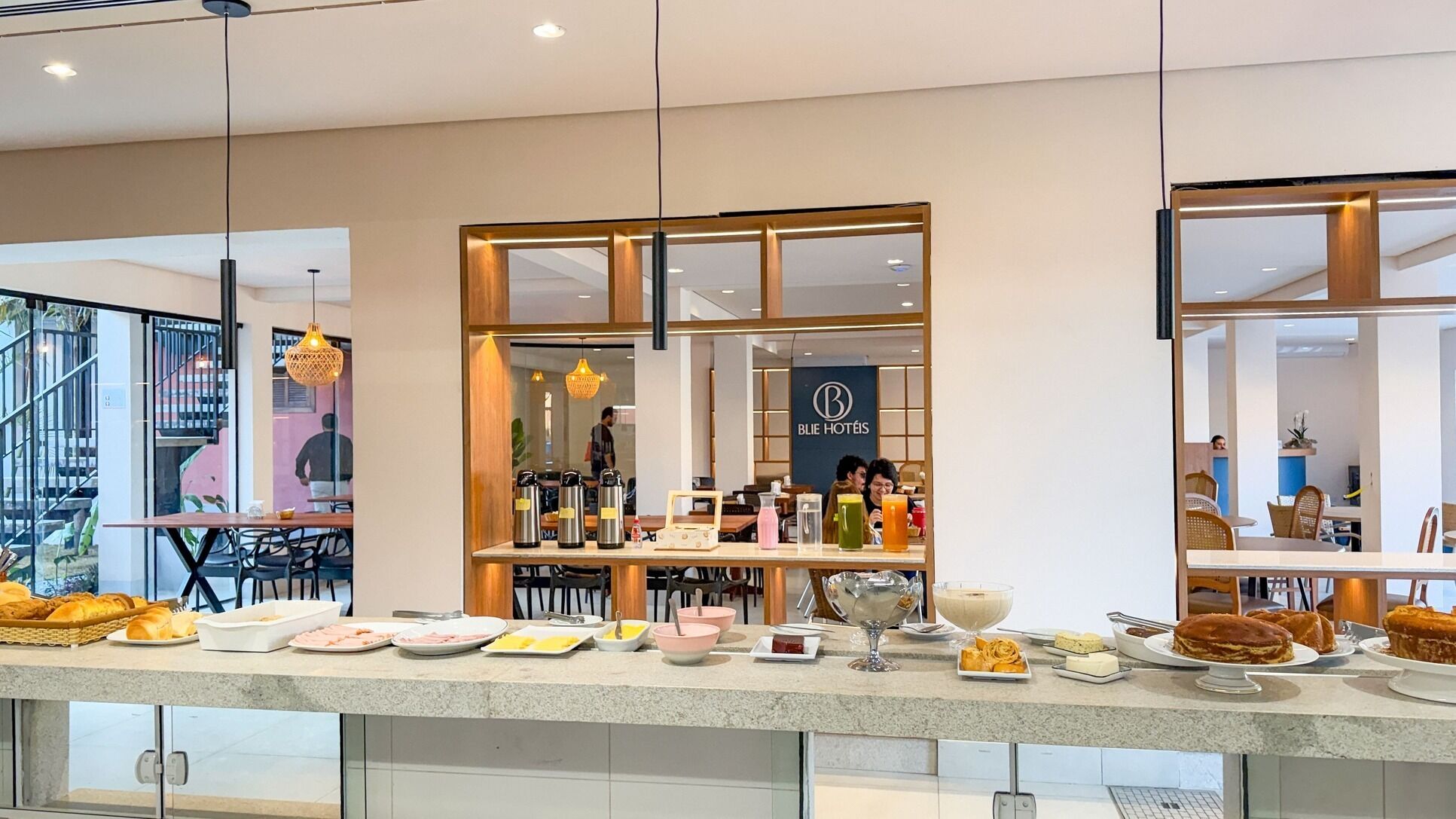 Un restaurante de hotel con un bufé, que incluye diferentes comidas y bebidas.