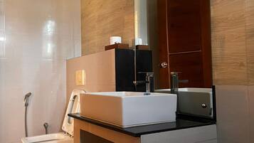 A modern bathroom with a white sink, a mirror, and a shower.