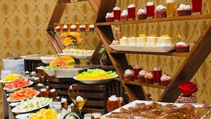 Un bufé con frutas, postres y bebidas variadas.