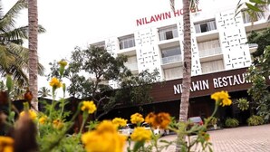 Un edificio con la señalización "NILAWIN HOTEL" y "NILAWIN RESTAURANT" a la vista.