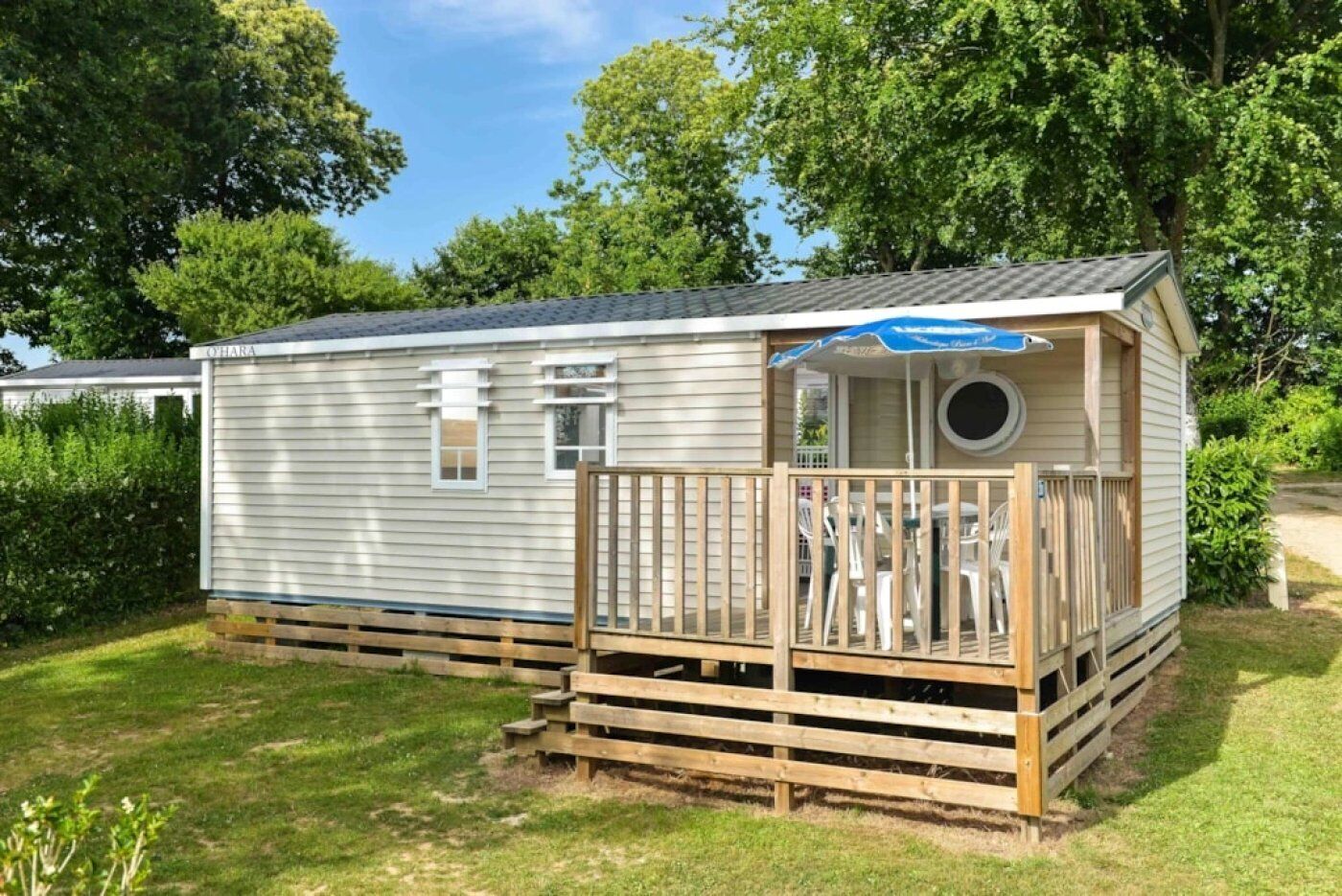 En campingvogn med en træterrasse og en lille veranda.